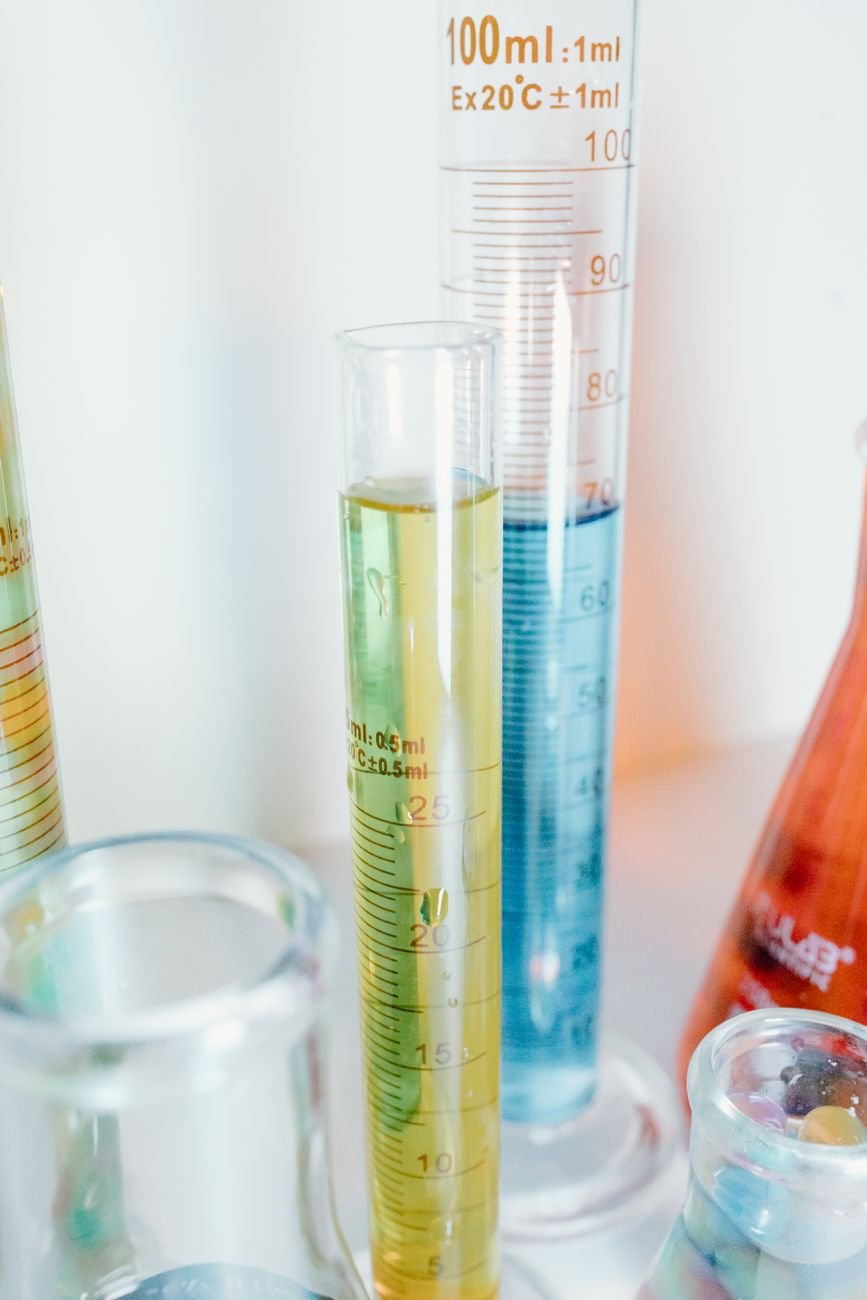 Close-up of colorful liquids in glass laboratory cylinders for scientific experiments.